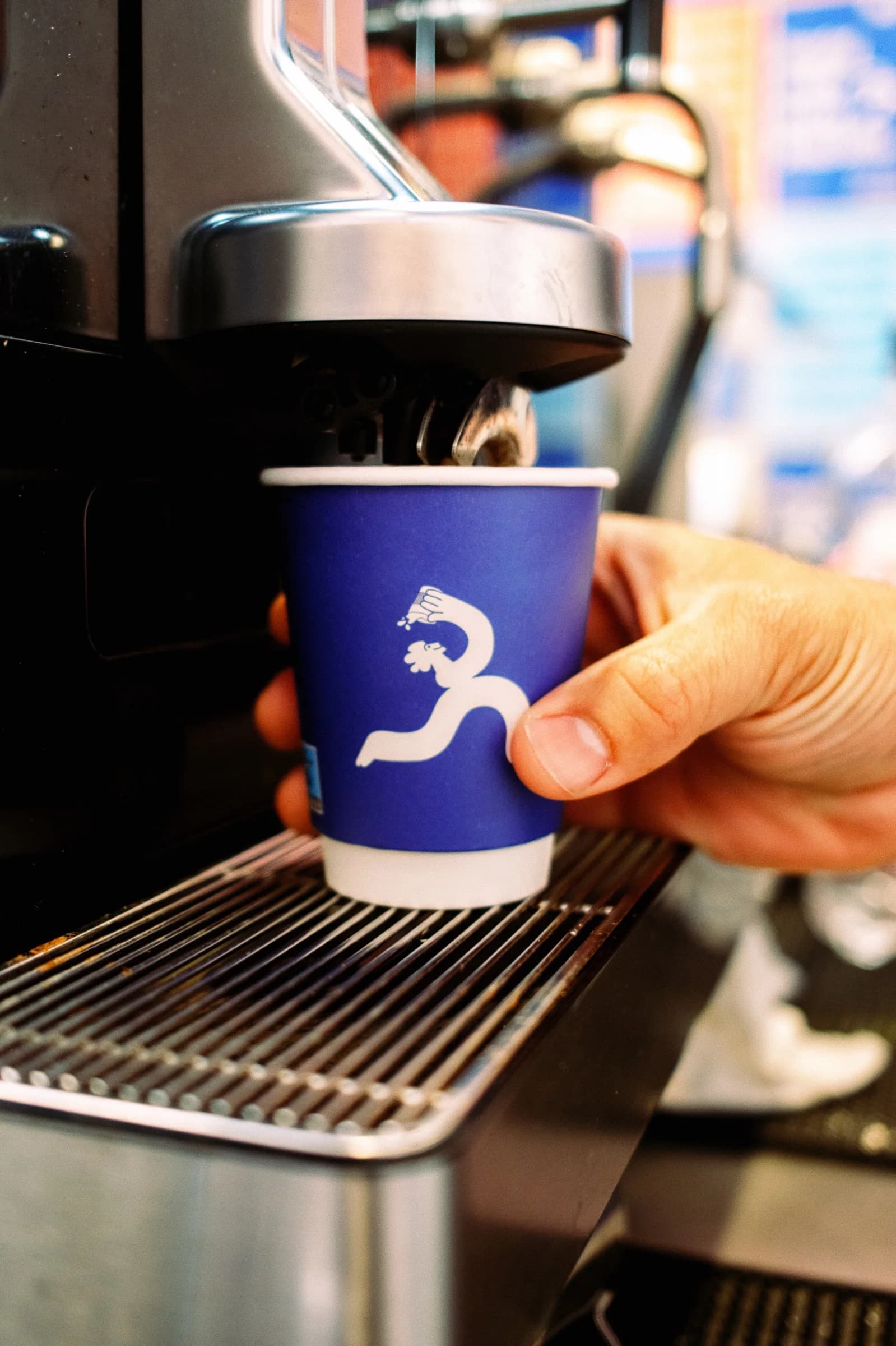 Café Noir paper cup being served from the coffee machine