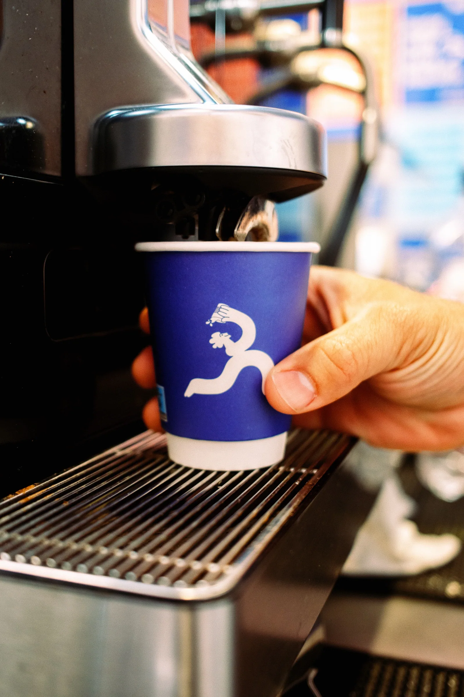 Café Noir paper cup being served from the coffee machine