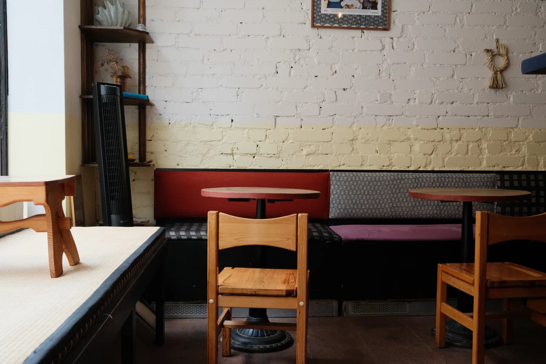 Café Tampopo's seating area with wooden chairs against a brick wall