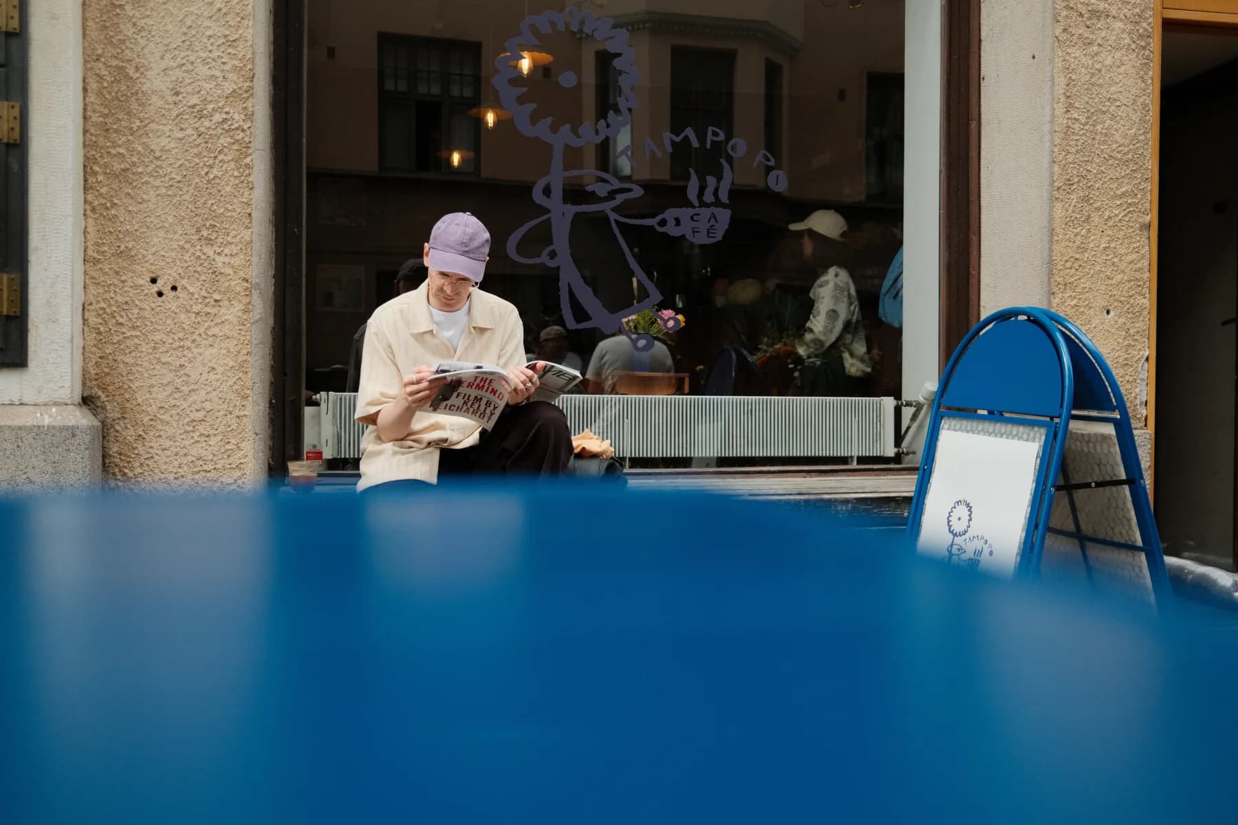 A guest reading outside Café Tampopo's window in Helsinki