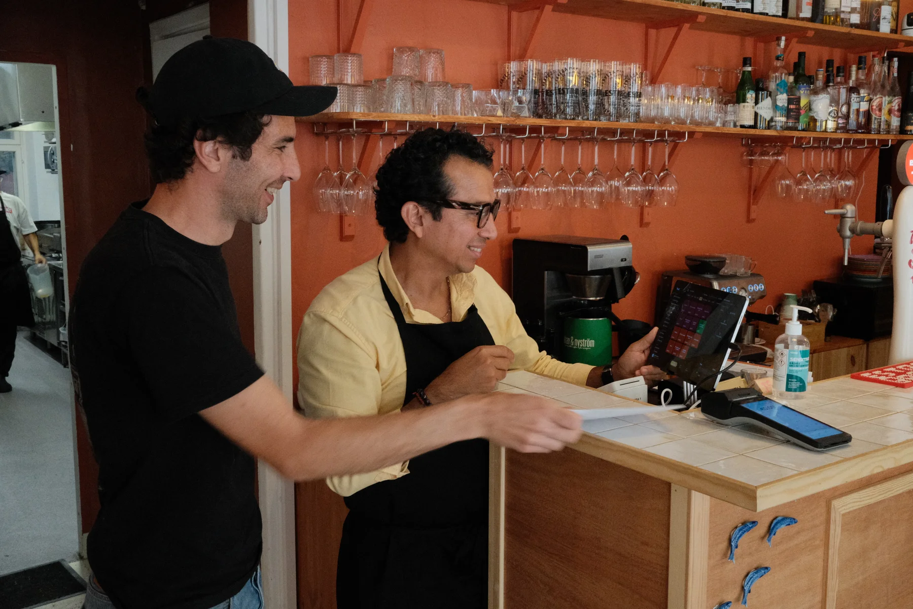 Alejandro and Felipe looking at a tablet at Casa Alejandro's counter