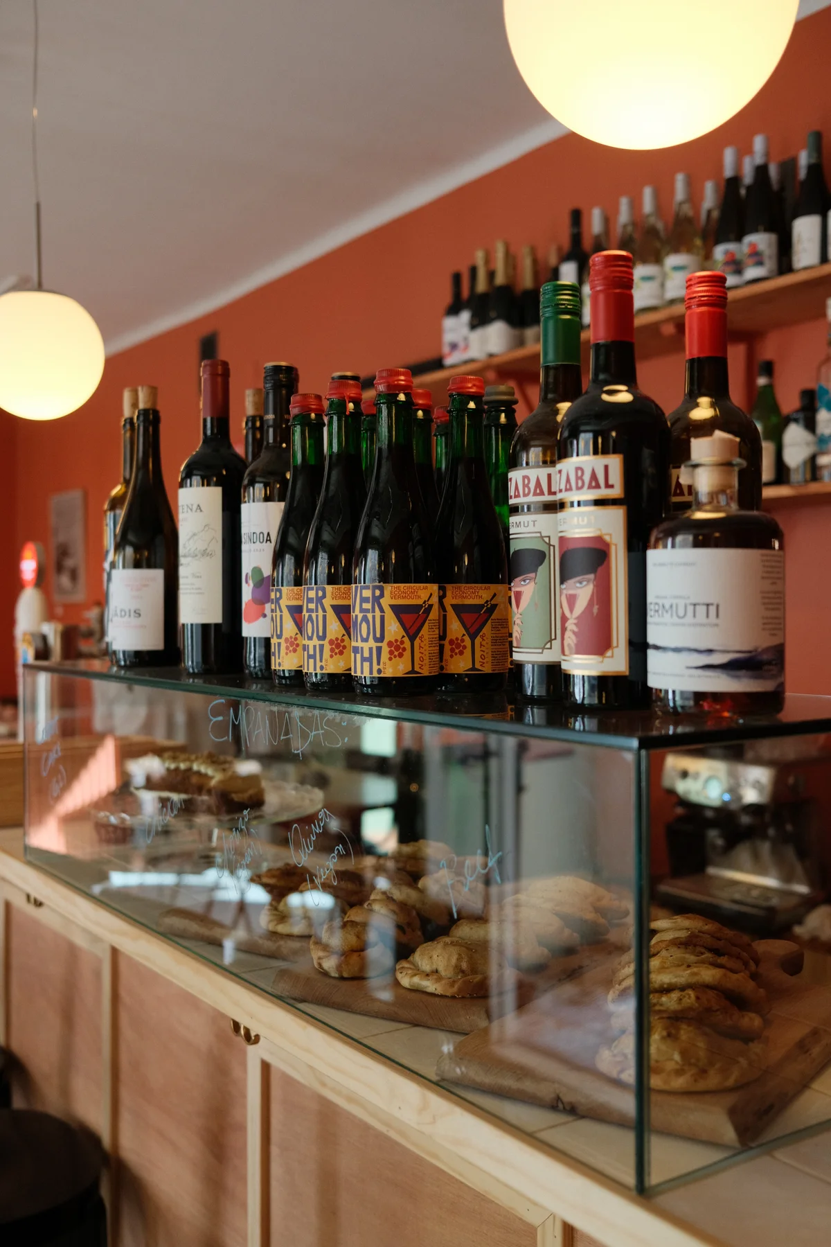 Wine bottles, glasses and a food display at Casa Alejandro's counter