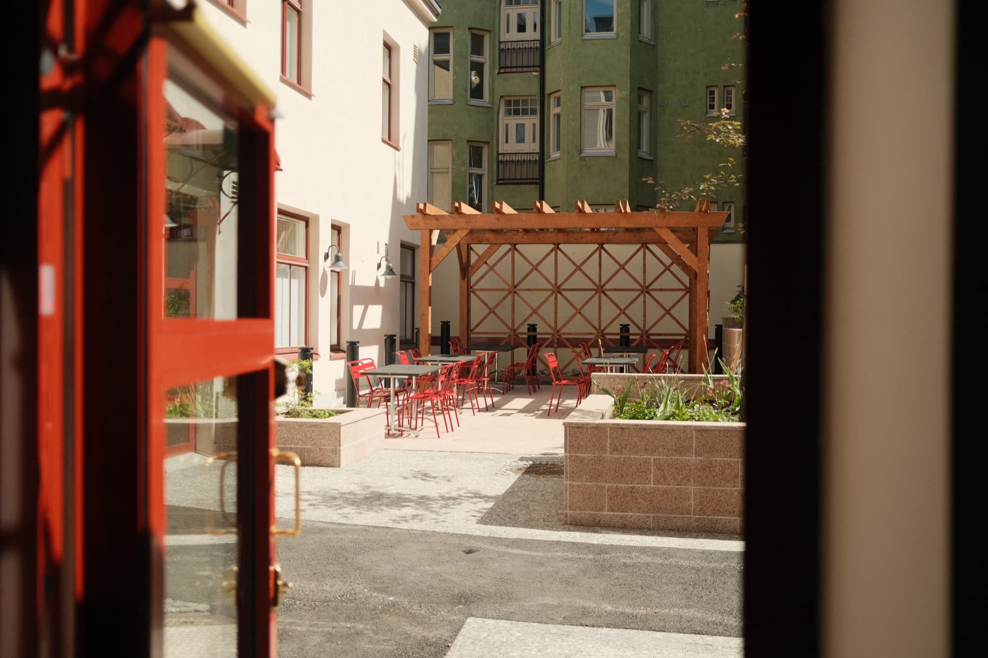 Focaccina's sunny courtyard terrace seen through the red doorway