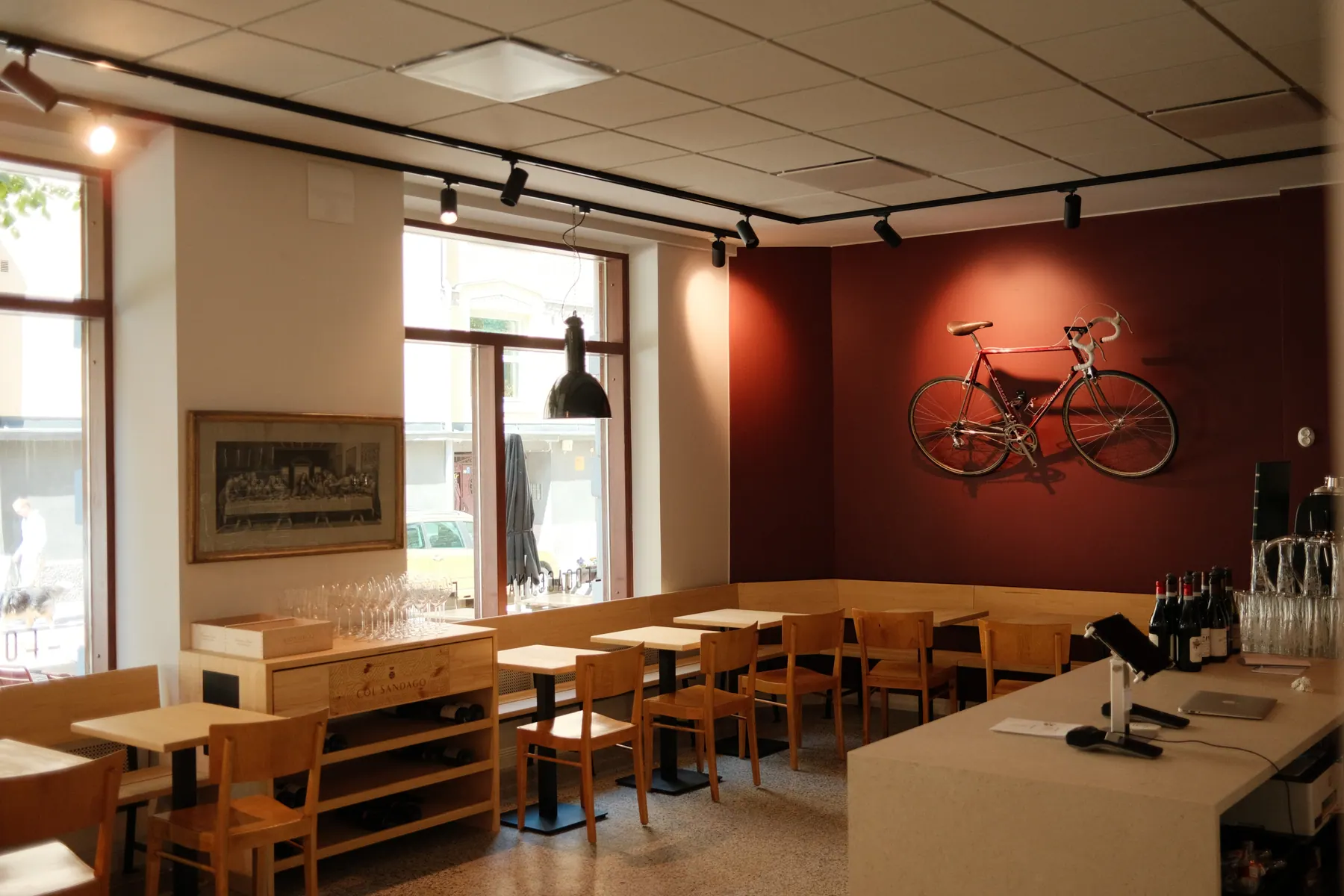 Focaccina's dining room with wooden tables and the red bicycle wall