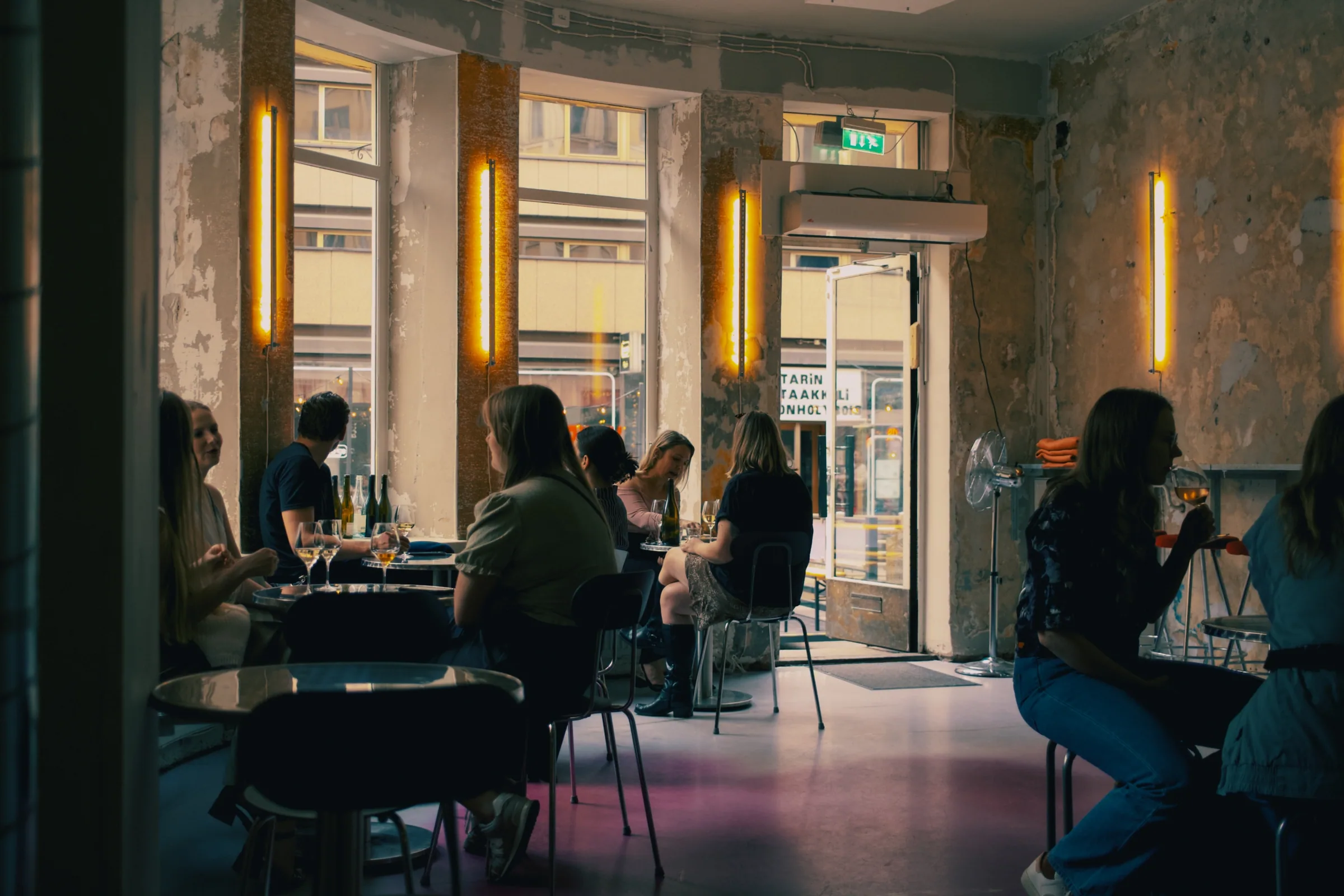 Guests seated inside Gadeplan with warm wall lights and street-facing windows
