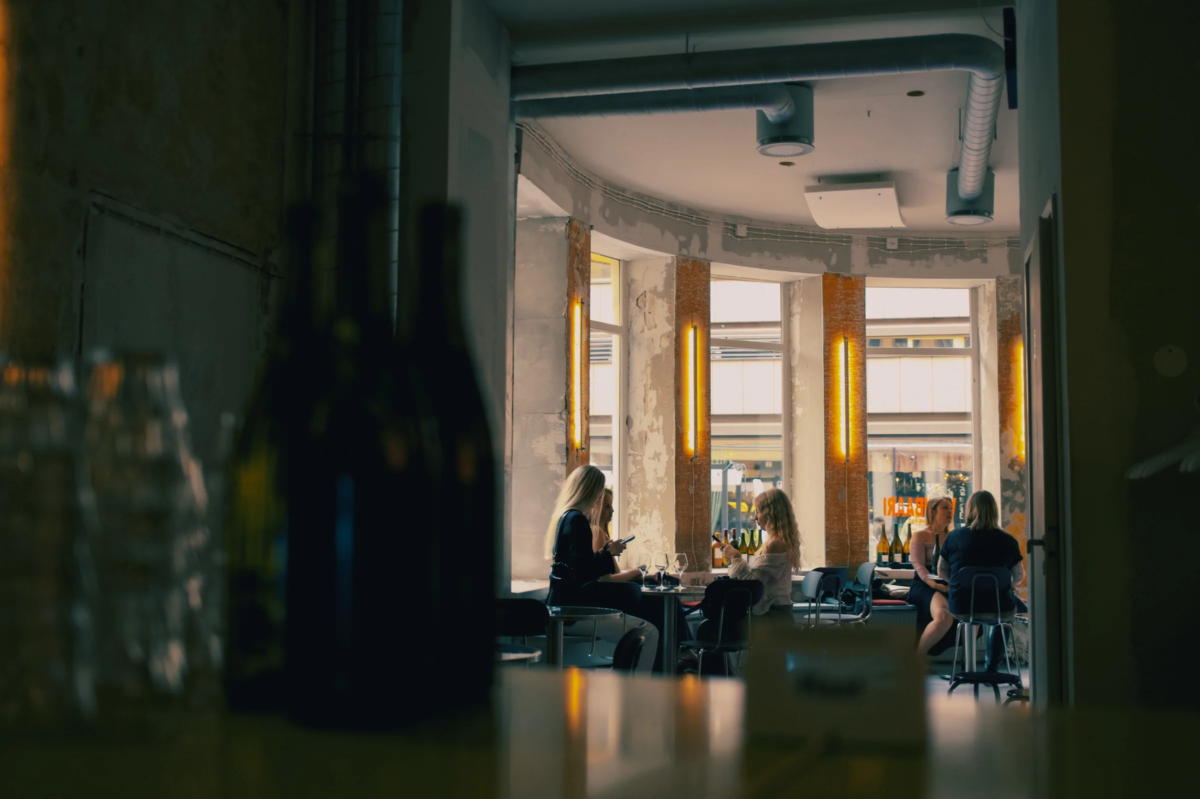 Gadeplan dining room seen past bottles toward the street-facing windows