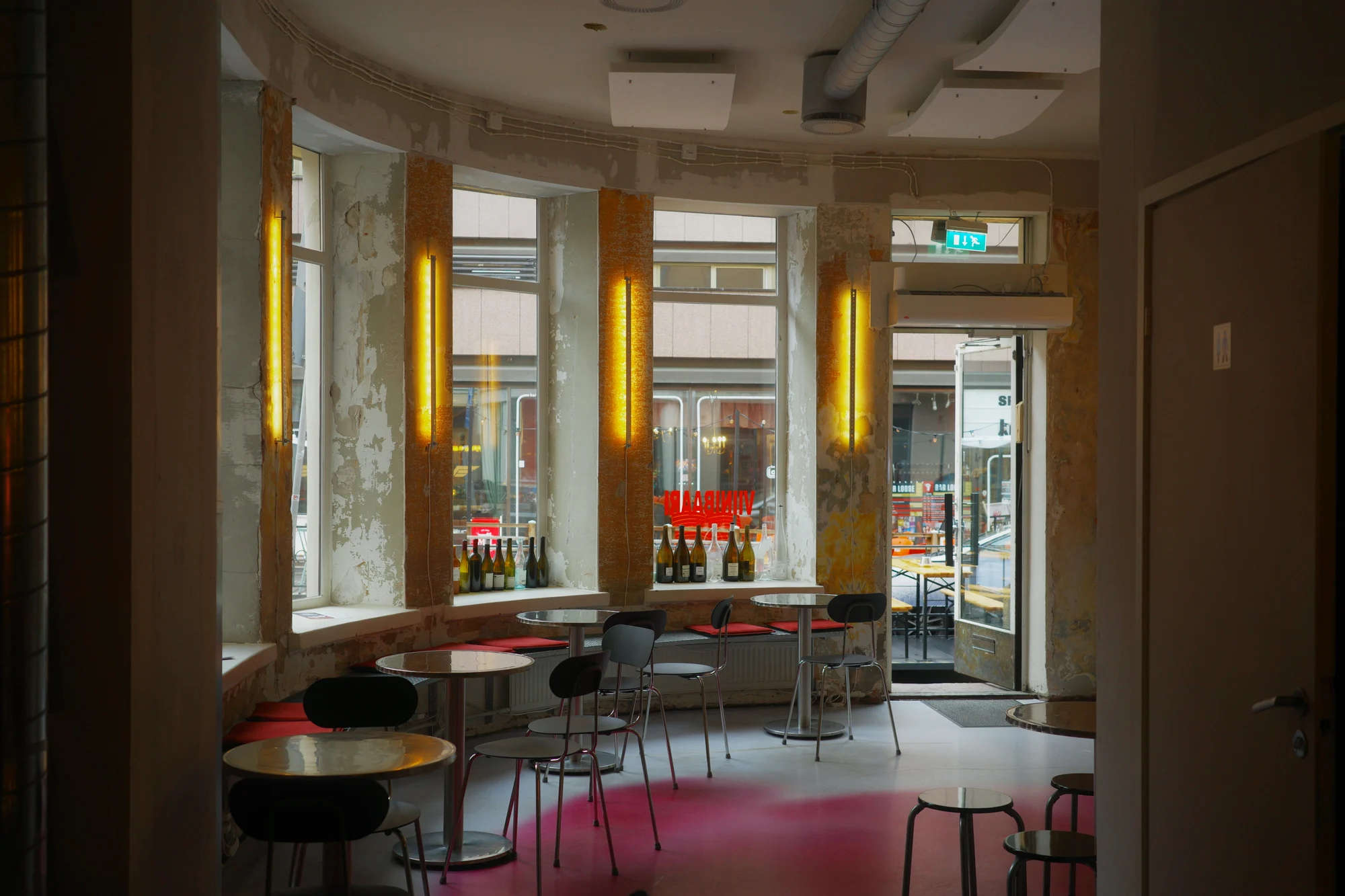 Empty tables and colourful seating inside Gadeplan