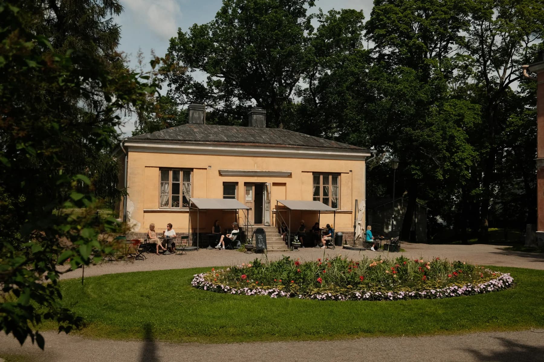 Kahvila Rakastan garden café exterior with summer guests at outdoor tables