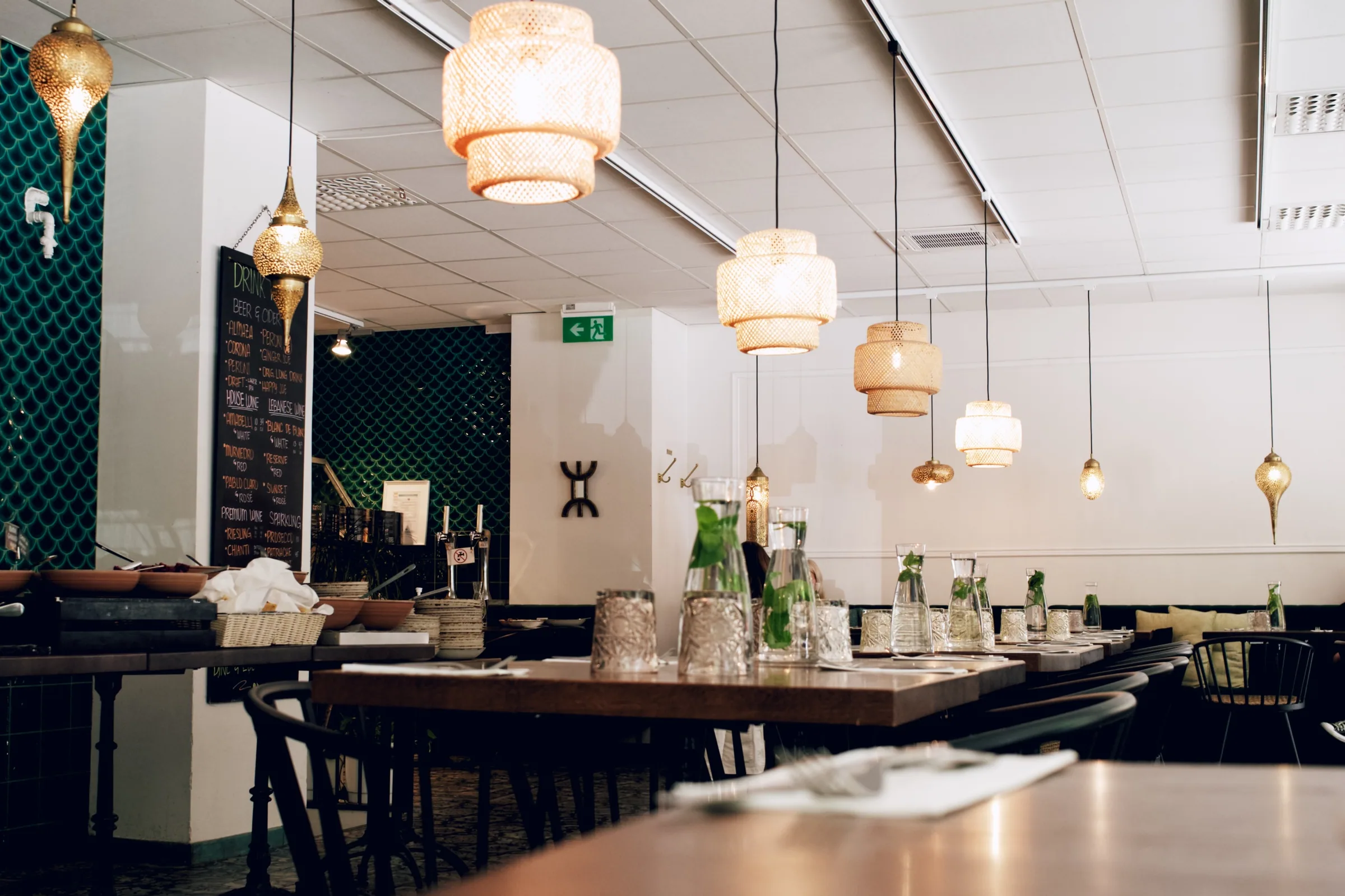 Levant dining room tables and pendant lights during service setup