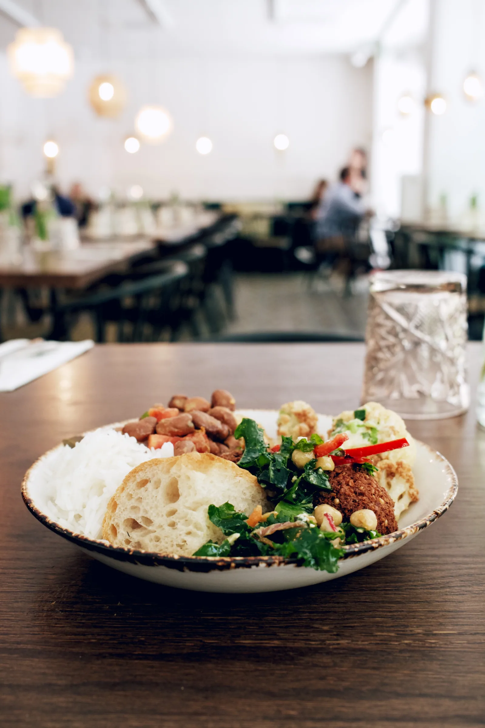 A Levant plate with rice, falafel, bread, beans, and vegetables