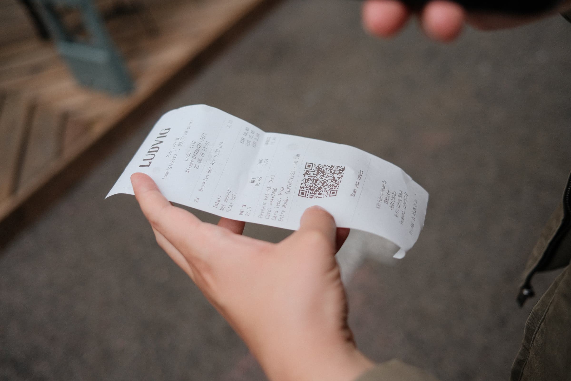 A Pub Ludvig receipt with a hosted receipt QR code held in the courtyard