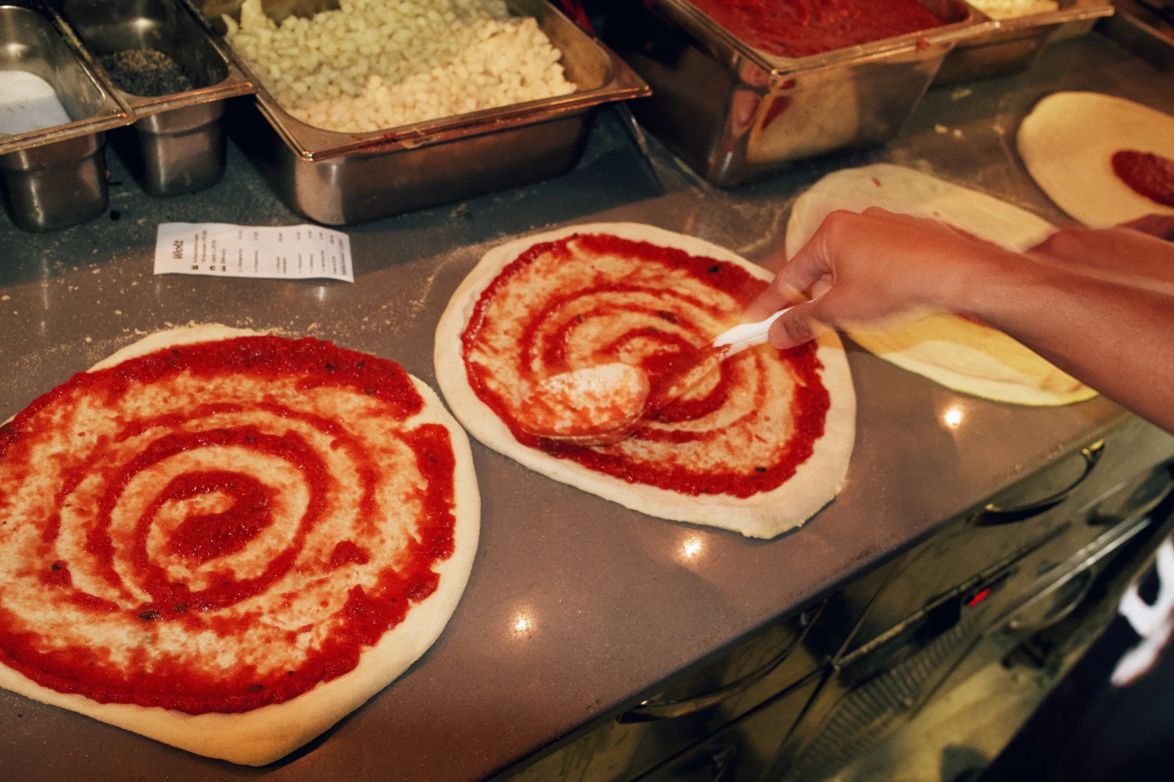 Pizza bases being sauced at Putte's Bar and Pizza