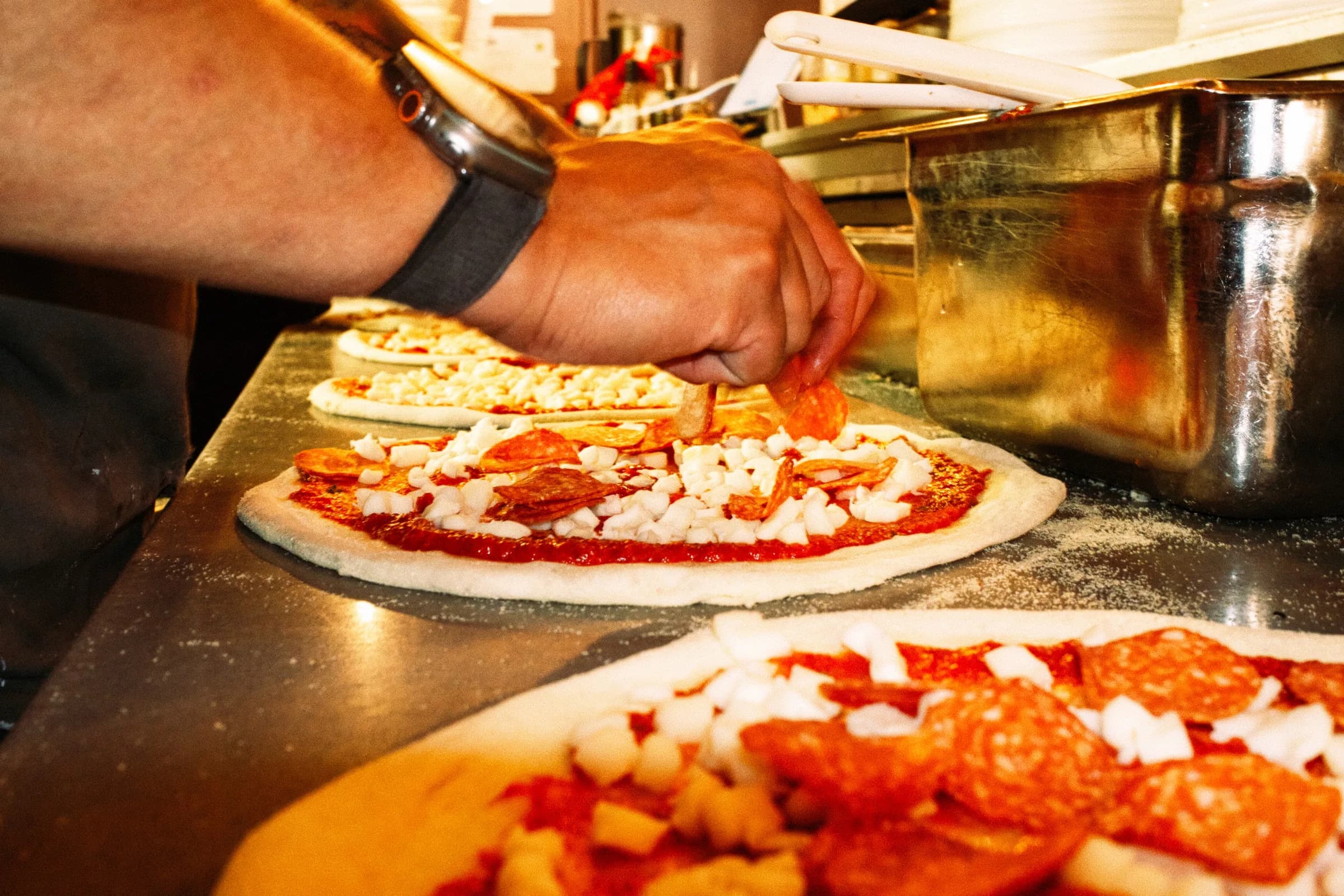 Pizza being topped at Putte's Bar and Pizza