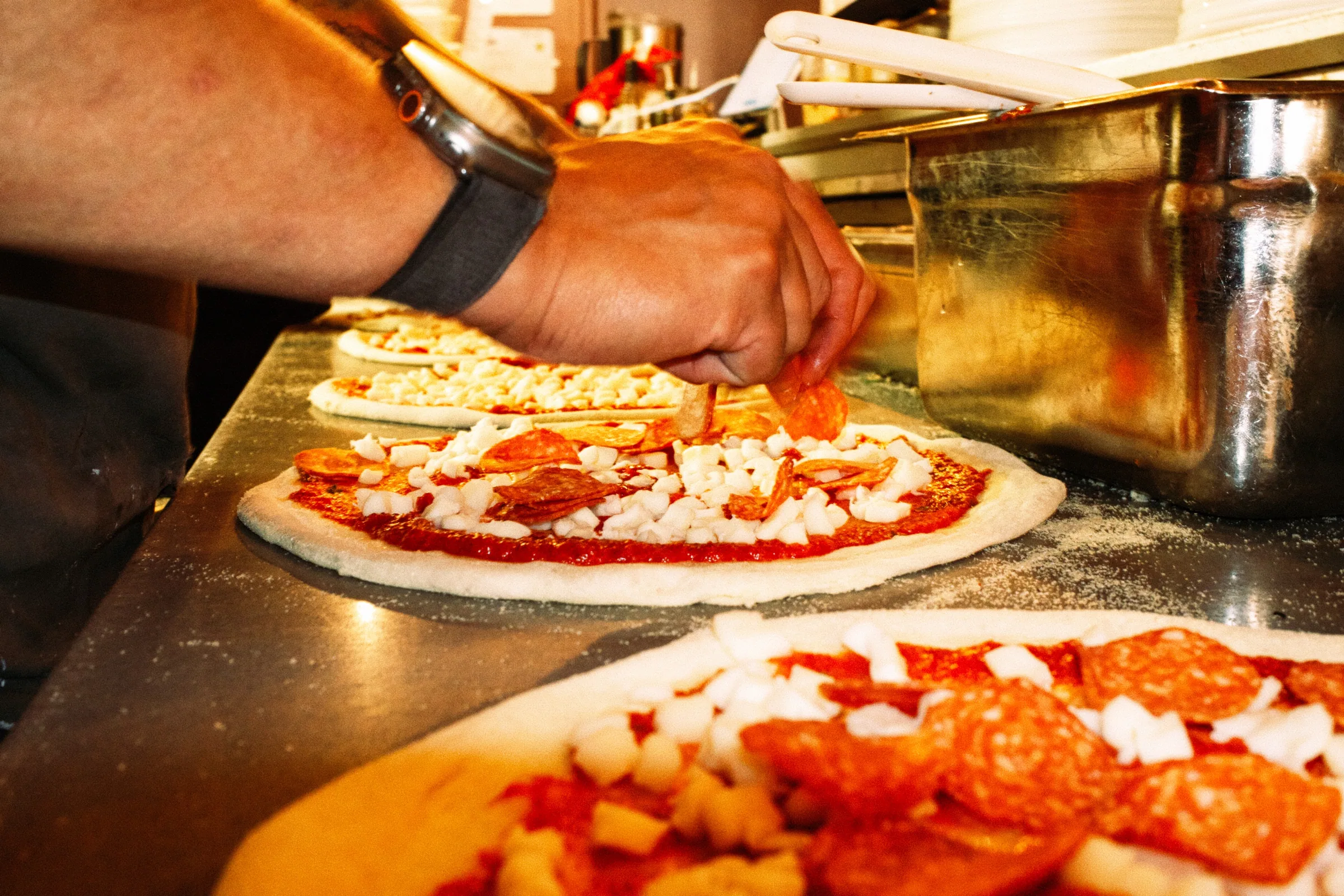 Pizza being topped at Putte's Bar and Pizza