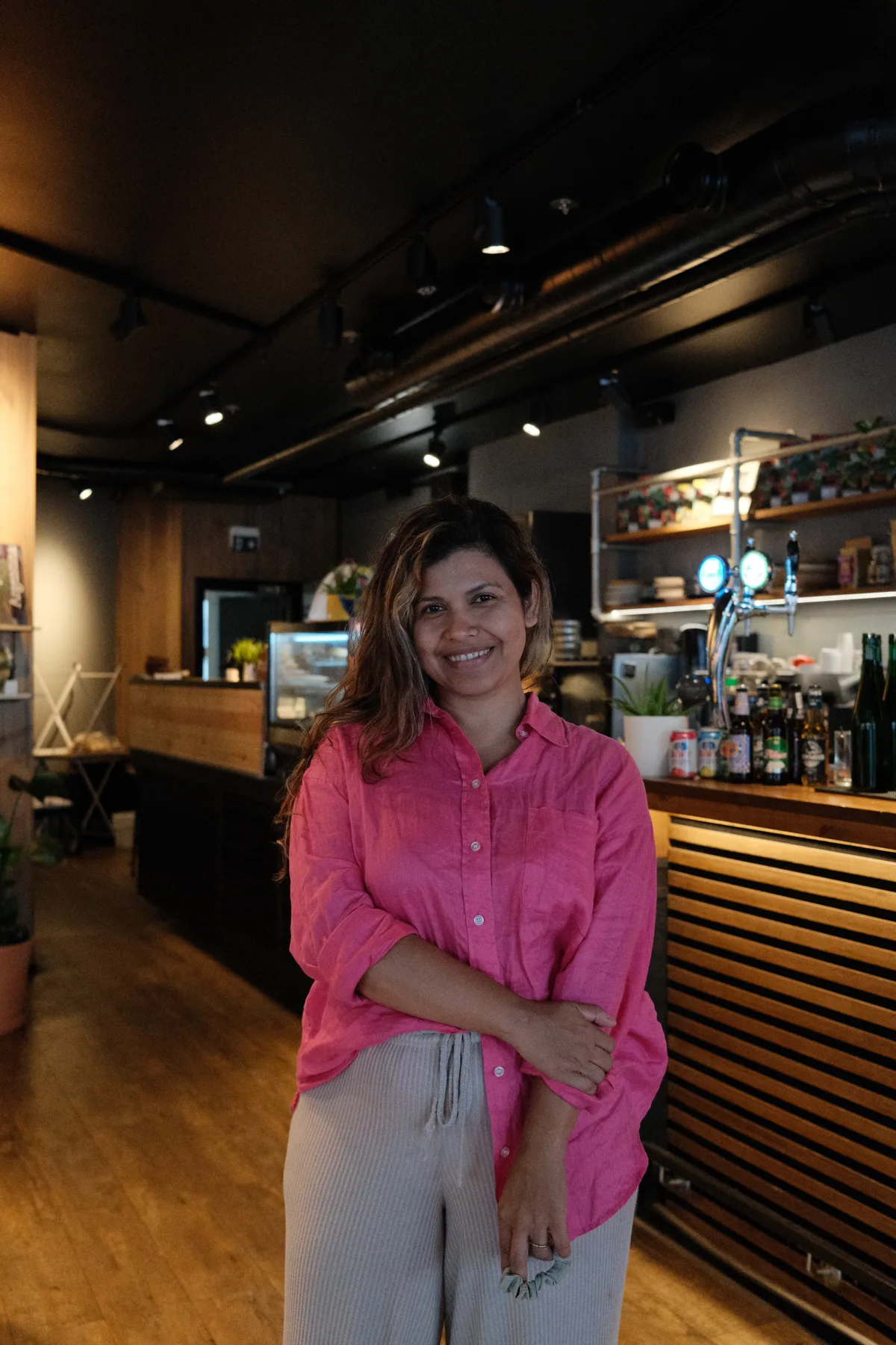 Ericka, co-owner of Tinku, standing in the dining room in front of the bar
