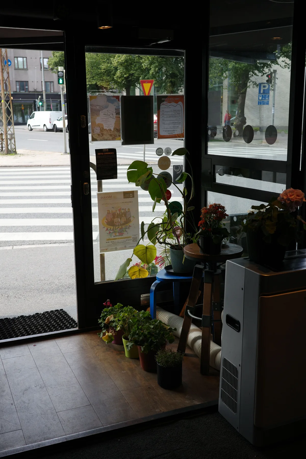 Tinku's open corner entrance with plants by the windows and the street outside
