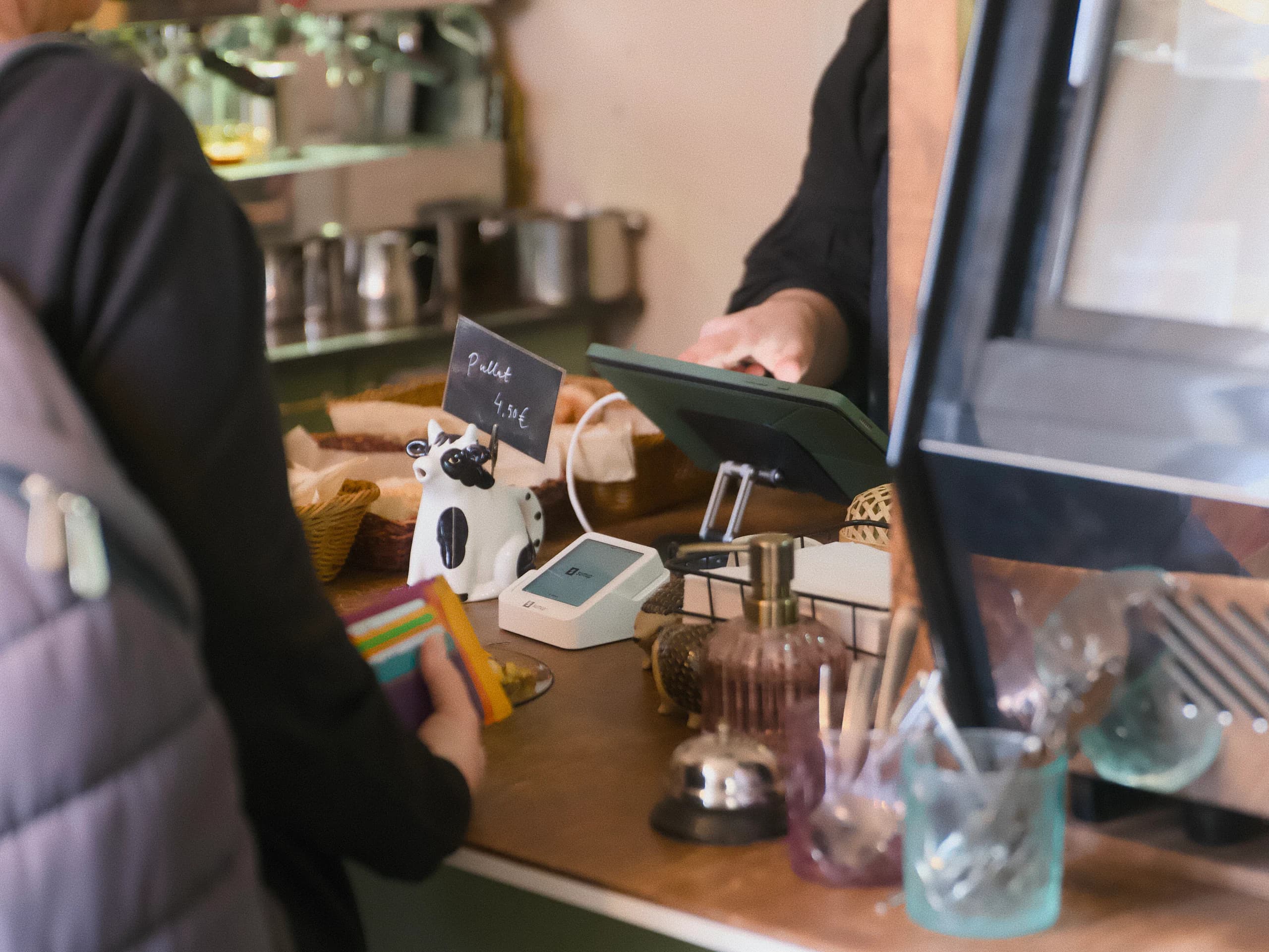 Customer paying by card at a cafe counter with Fiest POS visible